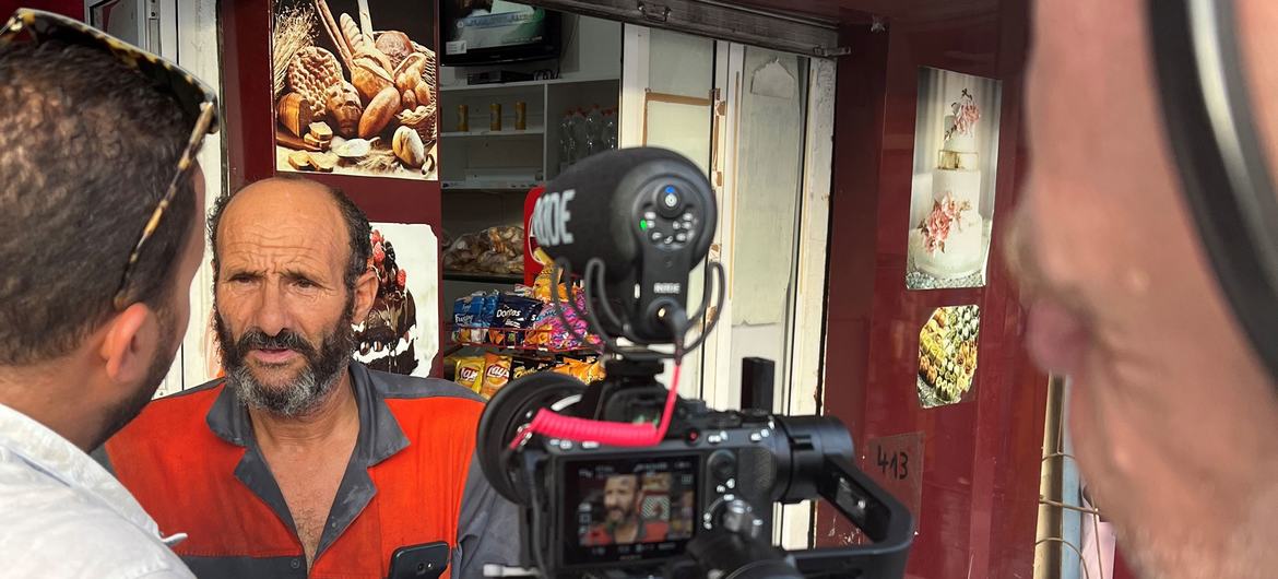 Seorang pelanggan mengobrol dengan UN News di toko roti lingkungan Tunis di Ettadhamen.